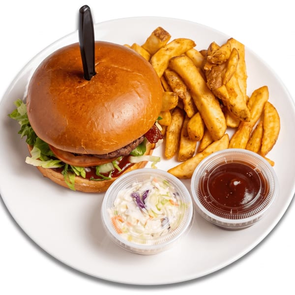 A burger with fries, coleslaw, and barbecue sauce on a white plate.