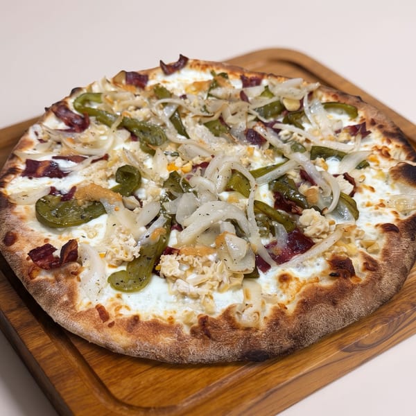 Wood-fired pizza topped with melted cheese, onions, green peppers, jalapeños, chicken, and crispy bacon on a wooden serving board.